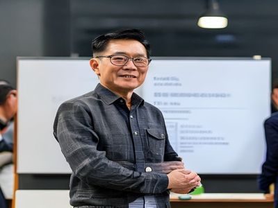 家庭教育内容总监王建国，站立于白板前讲解内容规划框架，神情自信，展现出丰富的内容管理与团队领导经验
